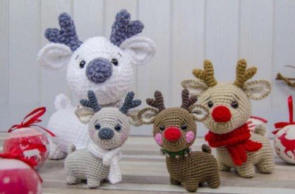Familia de amigurumis de renos sobre mesa de madera